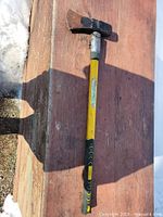 Full view of axe on wood surface showing complete handle and head