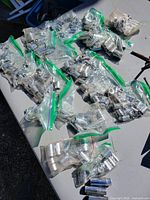 Overhead view of numerous zipper bags filled with chrome sockets spread on table