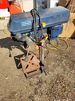 Full view of Mastercraft bench drill press on ground showing head, column, table, base and power cord