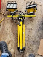 overall view of folded yellow tripod with two light heads and cord