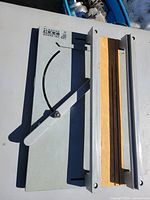 Full view of metal cutting board showing wooden bed, pivoting arm, fence and degree scale