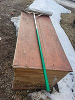 Full view of rake showing head, braces and green handle