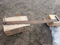 Full view of crosscut saw spanning two cartons