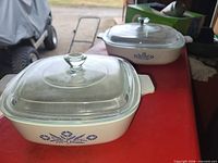Two Corning Ware casseroles with lids shown together