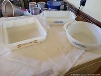 Three milk glass bakeware pieces on counter