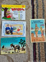 Front view of all four illustrated humour postcards