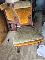 Front view showing carved frame, velvet seat and back, front casters