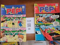 Both Pep Comics issues laid flat showing front covers