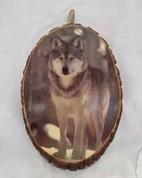 Full view of oval wood plaque showing wolf image and bark edge