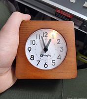 Front view showing full clock in hand