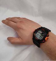 Watch on wrist showing digital display and size