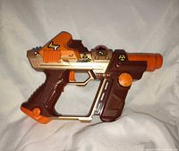 Left profile of brown/orange Lazer Tag Team blaster showing grip, trigger and top sensor