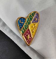 Front view showing heart shape and multicolor enamel with symbols