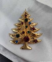 Front view showing gold-tone tree shape with multicolor rhinestones