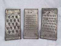 Front view of three graters showing different hole patterns and overall condition