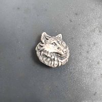 Front view of metal wolf head button