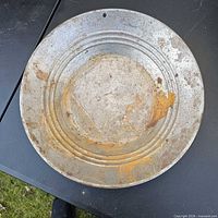 Top view of entire steel gold pan on table showing riffles and rust