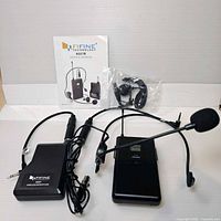 Full lot showing transmitter, receiver, headset mic, cable, manual