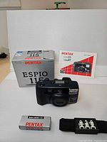 Camera, box, manual, remote packaging and strap with remote laid out