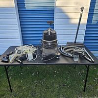 Full lot view showing canister vacuum and all accessories on table