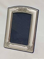 Front view of sterling silver photo frame showing ornate border and opening