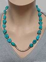 Necklace on mannequin showing turquoise nuggets and sterling front tube