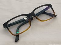 Front angled view of eyeglasses showing frame colour gradient and lens presence