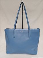 Front view of blue Kate Spade tote showing logo and overall condition
