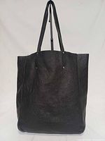 Front view of black pebbled leather tote with straps