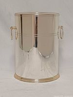 Front view of cylindrical silverplated wine cooler showing reflective surface and ring handle