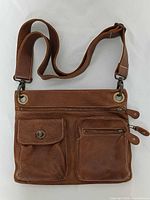 Front view showing pockets, zipper, strap attachment