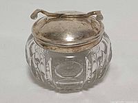Front view of cut crystal sugar bowl with silver-plated lid