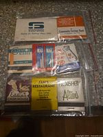 Group of seven vintage advertising matchbooks in clear bags