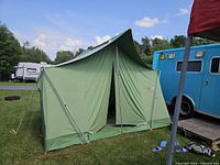 Exterior front view of green Coleman Oasis canvas tent assembled