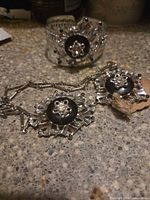 Necklace and cuff bracelet showing matching starburst motifs and colour