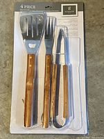 Front view sealed blister pack showing all four Gibson BBQ tools