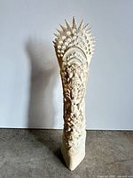 Full view of carved bone totem standing upright