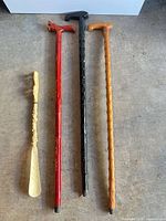 Four items laid out: three canes and one shoe horn
