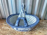 Oblique view of blue and white ceramic basket showing handle and pierced body