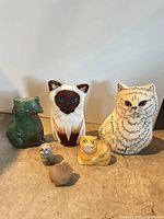 Group shot of all six ceramic cat figurines