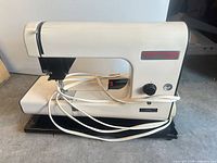 Full view of Cortina Super 2 sewing machine showing body, base and cords