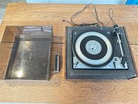 Dual 1029 turntable and dust cover side by side on table
