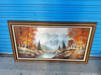 Full view of framed painting against blue background