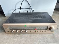 Front view of Marantz SR225 receiver showing all controls and attached power cord