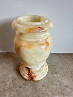 Full view of cream onyx urn vase on pedestal base