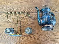 Overview of all items: brass menorah, silver-plate teapot, two candlesticks