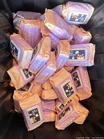 Container filled with many sealed lavender pet wipe packs