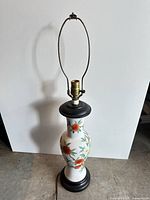 Full view of lamp showing ceramic body, base, socket, harp and cord