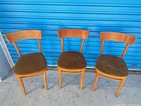 Three matching wooden chairs front view