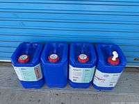 Four blue Reliance Aqua-Pak water jugs lined up against blue door